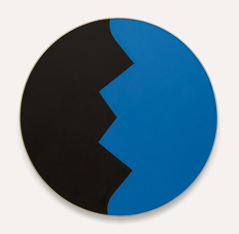 Circular 'tondo' canvas made up of two shapes perfectly fitting into each other. The shapes have the appearance of a mountain range on it's side running top to bottom. Black on one side and blue on the other give the painting a feeling of stillness, like a night sky.
