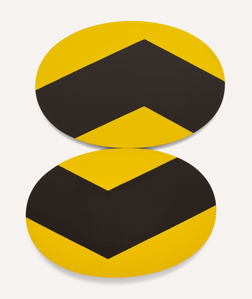 Two oval canvases wider than tall, they are the same size and balanced one on top of another. The canvases are yellow with a very thick black 'check' shape cutting into the top and bottom upwards on the top and downwards on the bottom