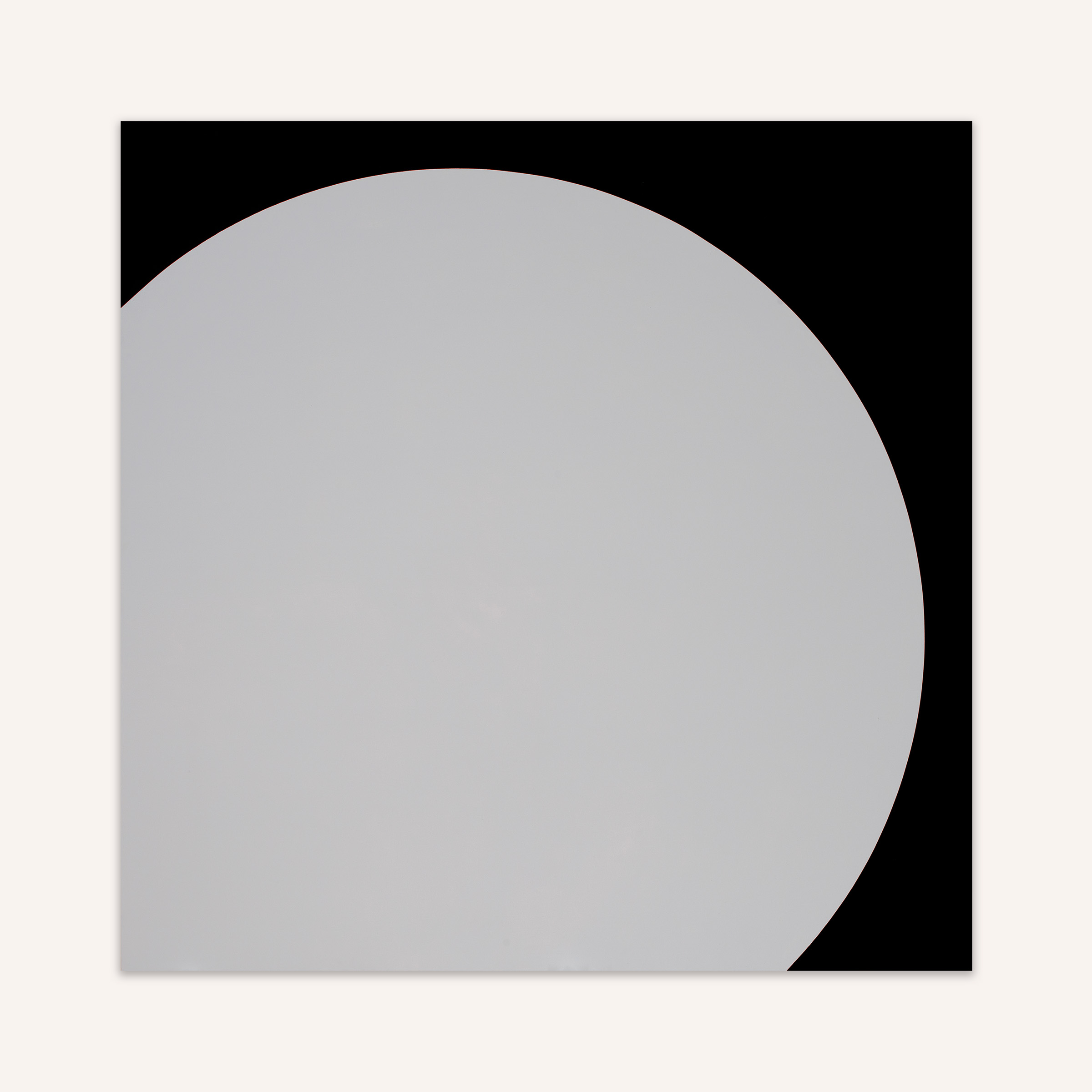 The painting Prairie Moon by Leon Polk Smith is a square canvas with a large light grey circle so large that it overlaps the canvas on the bottom left, exposing a round edge in black running from top left to bottom right.